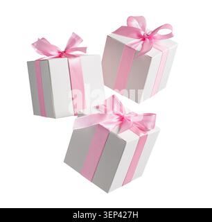 White gift boxes with pink bows flying and falling isolated on white background Stock Photo