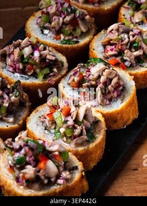 Golden bread slices topped with vibrant, fresh chopped mushrooms and herbs. Colorful mix of red peppers, green onions, and minced garlic. Plated on da Stock Photo