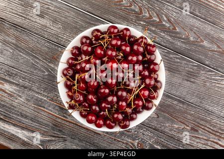 red cherry bowl on wood background top view Stock Photo