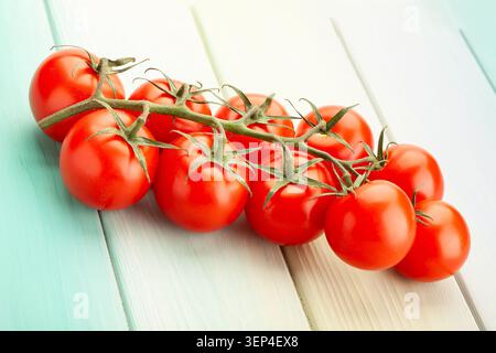 cherry tomato branch on blue wood background Stock Photo