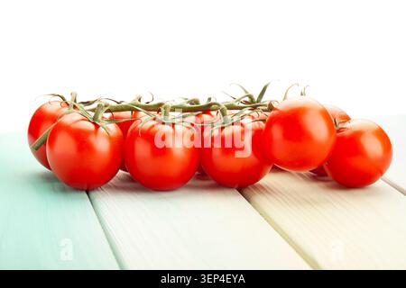cherry tomato branch on blue wood background on white Stock Photo