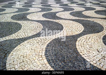Calçada portuguesa cobblestone pavement, wave motif, limestone and basalt, Lisbon, Portugal Stock Photo