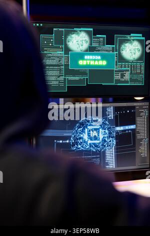 Cybercriminal coding on PC getting access granted message, evading security with stealth malware while evil man successfully making script hiding malicious code from detection systems. Stock Photo