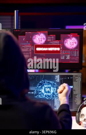 Hacker receiving system hacked message after attacking PCs using AI malware software while rogue software developer in secret lair trying to hide online activity after stealing data. Stock Photo