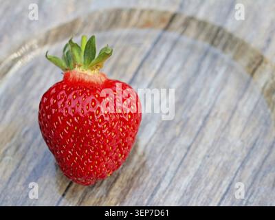 A close-up of bright red strawberry on a woody background. Organic fruit from Horn-Bad Meinberg Stock Photo