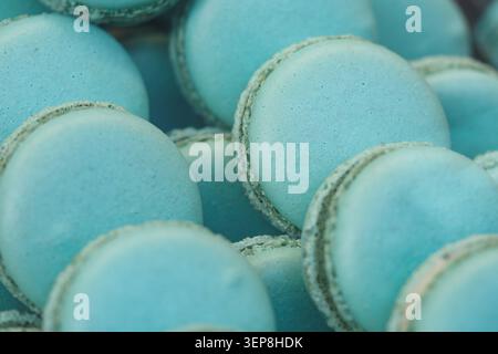 Blue macarons stacked in a dessert display at a bakery Stock Photo