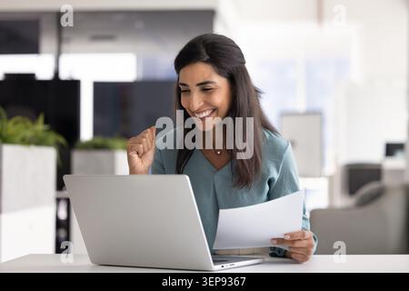 Happy business woman celebrating success at work Stock Photo