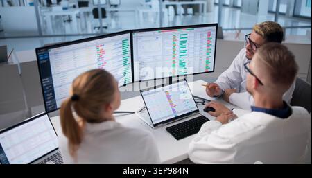 Medical Billing Team Works Together Reviewing Coding Data On Computer. Stock Photo