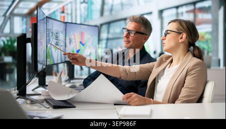 Architect And Client Review House Renovation Plans Using Digital Drawings Together. Stock Photo