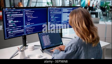 Woman Developer Writes Code On Laptop Using Cloud-based Programming Tools. Stock Photo