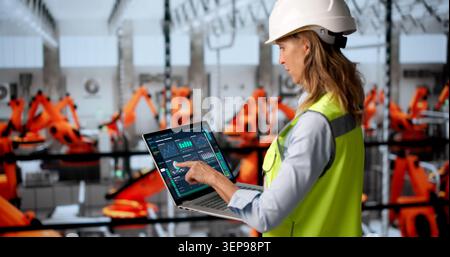 Experienced Woman Engineer Uses Laptop To Monitor Industrial Plant Systems. Stock Photo
