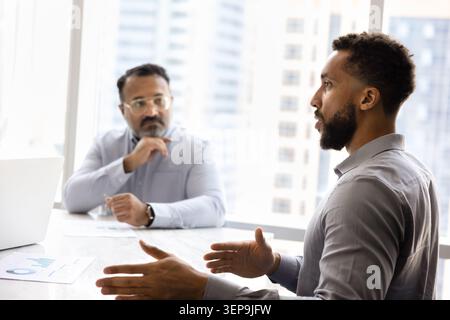 Young American businessmen talking during formal meeting Stock Photo