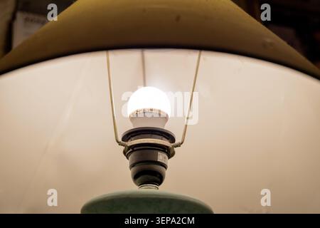 Close up shot of an illuminated energy saving V-TAC LED light bulb inside a lamp holder. Stock Photo