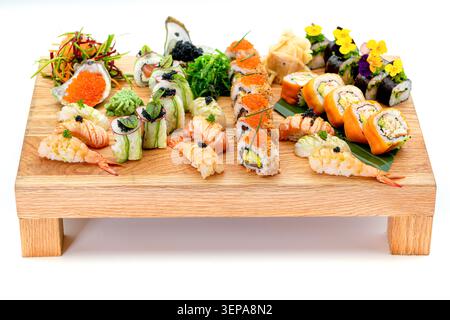 Assorted sushi and nigiri selection on wooden serving board isolated on white background Stock Photo