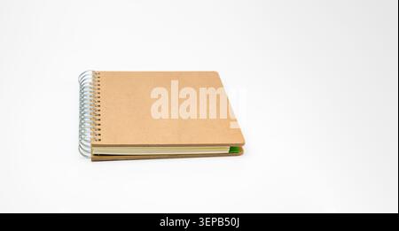 Brown craft paper spiral notebook lying horizontally on a clean white background, creating copy space, symbolizing education, business, and creativity Stock Photo