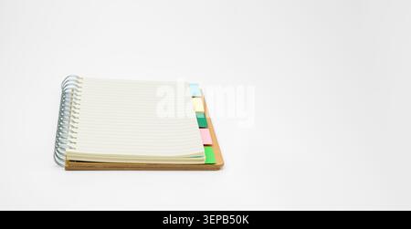 Open spiral notebook with lined pages and a brown cover, colorful divider tabs visible clean stationery for organization, planning, notes, study or of Stock Photo