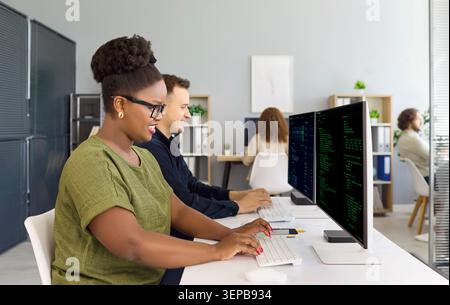 Developers coding at computers in office with programmers teamwork for startup Stock Photo