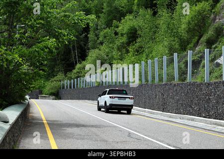 White Pickup Truck Driving on Mountain Road Stock Photo