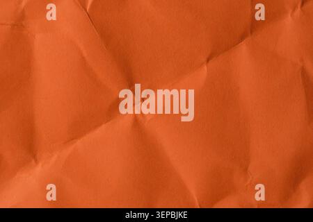 A textured layer of crumpled orange paper fills the space with warmth and depth. Stock Photo