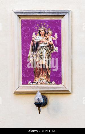 Framed Virgin Mary Madonna And Child Statue On Wall With Decorative Lamp Stock Photo