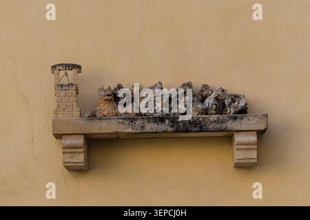 Decorative Stone Shelf With Weathered Rocks and Miniature Well on Yellow Mediterranean Wall Stock Photo
