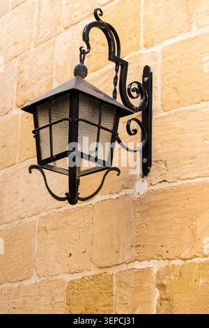 Vintage Black Iron Lantern Wall Lamp Mounted On Sandstone Wall Outside Historic Building Stock Photo