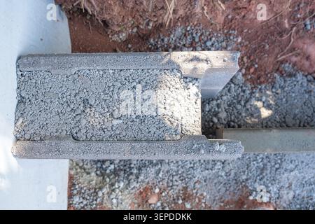 Top-down detailed shot of a hollow concrete block filled with crushed stones and gravel at a construction site. Perfect for building materials Stock Photo