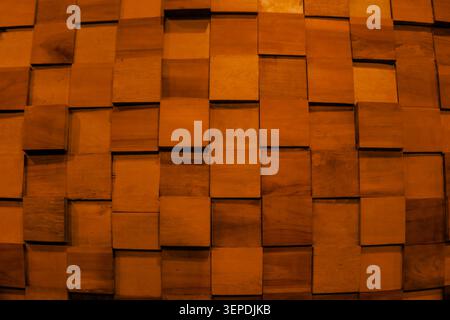 Warm wooden squares form a textured pattern. Each plank has unique grain and natural imperfection. Soft lighting enhances depth and organic warmth. Perfect for modern interiors or design backgrounds Stock Photo