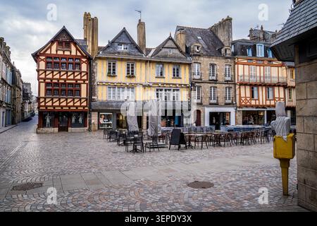 View of Place au Beurre in Quimper, France. The shot shows the stone paving of a medieval square surrounded by ancient colorful half-timbered houses, Stock Photo