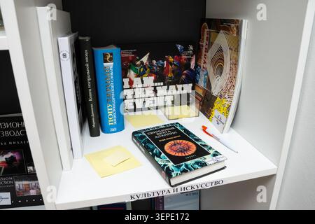 Moscow, Russia - April 16, 2016 - Assorted books and magazines on a white shelf including educational and culture themed publications with writing mat Stock Photo
