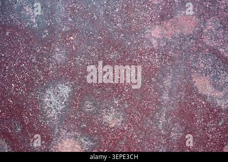 Red porphyry stone texture in macro view, showing imperial purple rock, mineral crystals and an abstract natural geological surface. Stock Photo