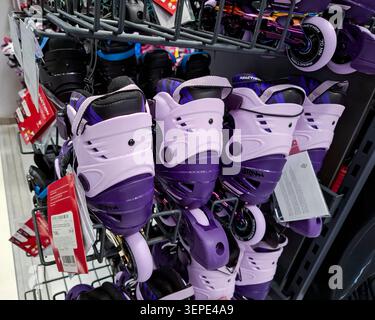 Voronezh, Russia - April 11, 2026.Close up view of kids inline roller skates in purple and lilac. The skates are hanging on a retail rack, ready for p Stock Photo
