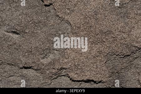 Rough dark gray granite stone showing natural uneven texture and detailed surface Stock Photo