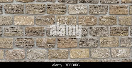 Porous limestone brick wall forming a rugged textured surface background Stock Photo