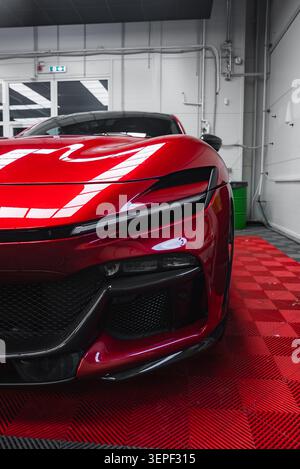 Front left quarter of Ferrari 296 GTB in modern workshop lighting Stock Photo