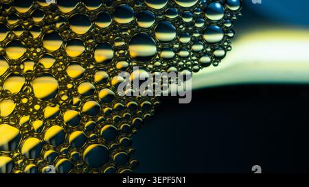Liquid bubbles forming an abstract macro surface with golden highlights Stock Photo