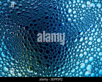 Blue and teal soap bubbles creating an abstract pattern on a liquid surface Stock Photo