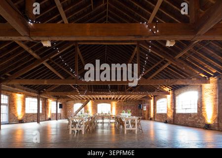 wedding room with a wooden beam ceiling and table set up for banquet Stock Photo