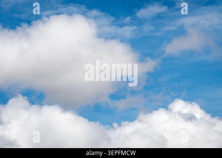 beautiful cloudscape featuring bright white clouds against a deep blue sky. This versatile nature background conveys themes of freedom and hope Stock Photo