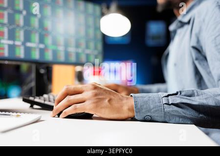 Financial auditor inspecting capital funds stock market trends to obtain revenue for business operations, remote accounting work; african american expert analyzing global exchange balance. Stock Photo