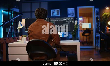 Engineer arriving in home office with mug of coffee in hand, ready to start coding using javascript. IT expert beginning remote work shift, holding cup of tea, updating company software. Stock Photo