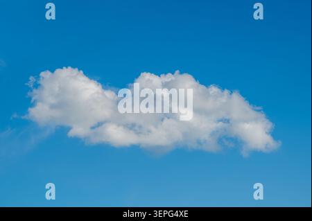 Single White Cloud Floating In Clear Blue Sky Stock Photo