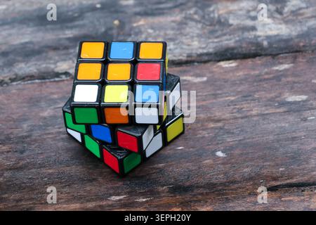 Colorful puzzle cube brain teaser logic toy plastic mixed colors challenging playful on rustic wooden surface creative thinking problem solving leisur Stock Photo