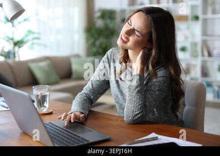 Teleworker complaining working at home and suffering neck ache Stock Photo