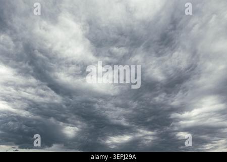 Dramatic gray clouds covering the sky. Dark storm weather background photo Stock Photo