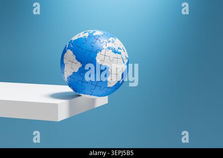 Puzzle globe balancing on the edge of a platform, symbolizing global risk, uncertainty, fragility, and the urgency of conservation Stock Photo