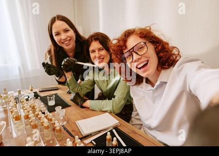 Portrait of Adult Women Gathering at Table and Taking Selfie  Stock Photo