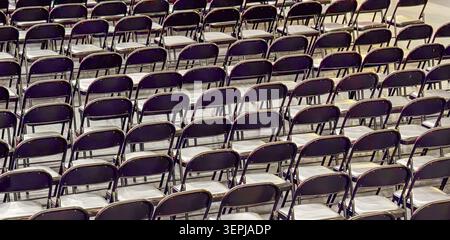 empty black folding chairs in rows at event hall, concept of conference, meeting, education, banner Stock Photo