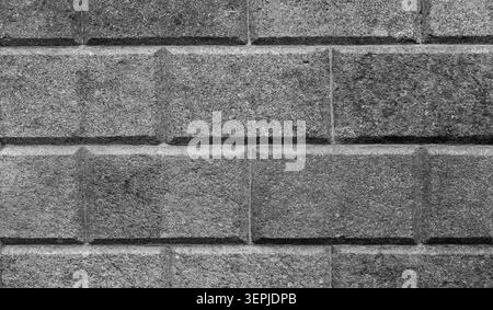 Dark gray, speckled granite block wall with beveled joints, black and white background photo texture Stock Photo
