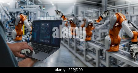 Smart industry control concept with hands holding a tablet for monitoring automated robotic machines in a modern manufacturing facility, representing Stock Photo